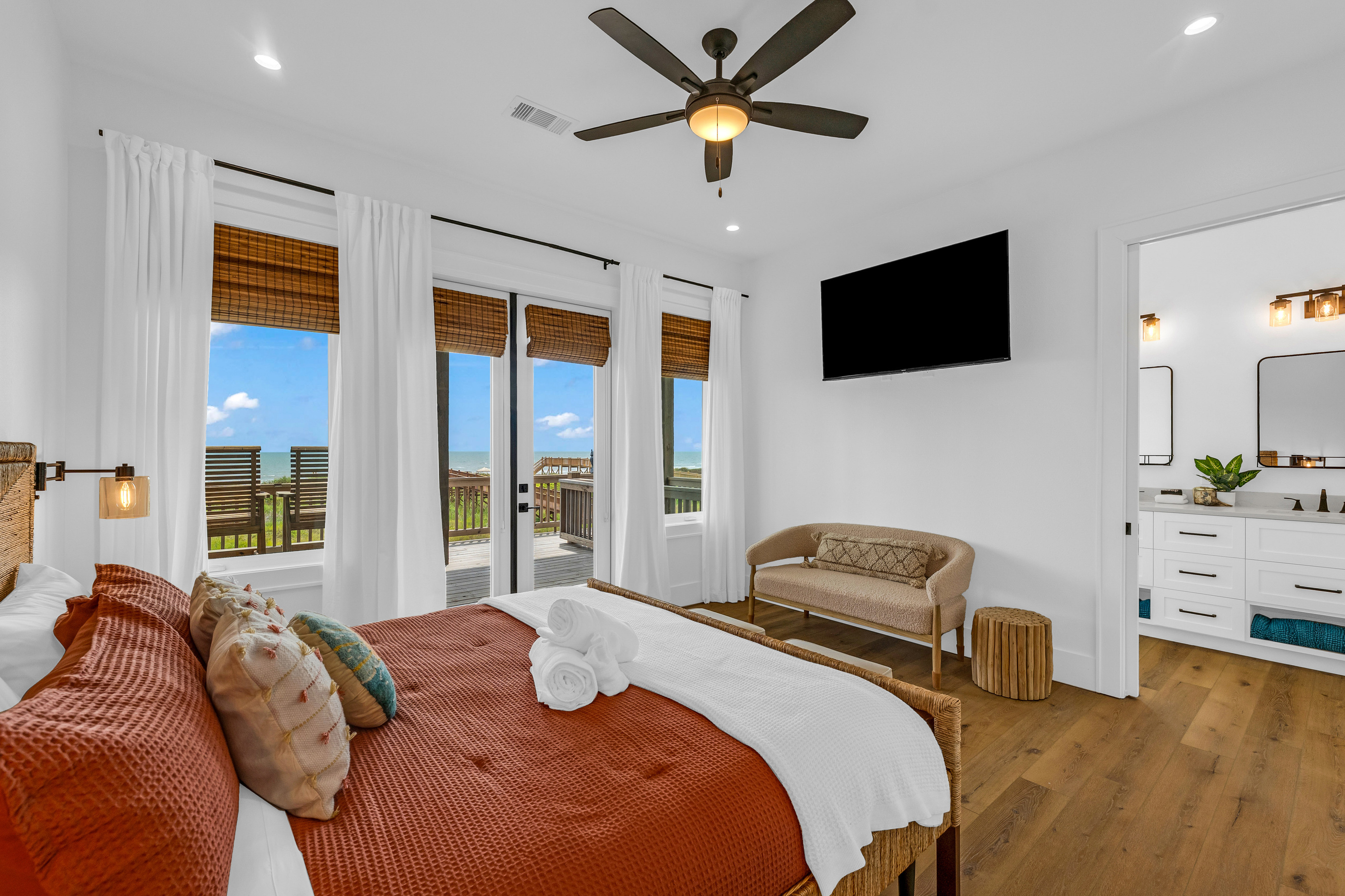 Cair Paravel: A mounted TV, cozy settee, and a peek through to the ensuite round out this bright, sunny guest suite.
