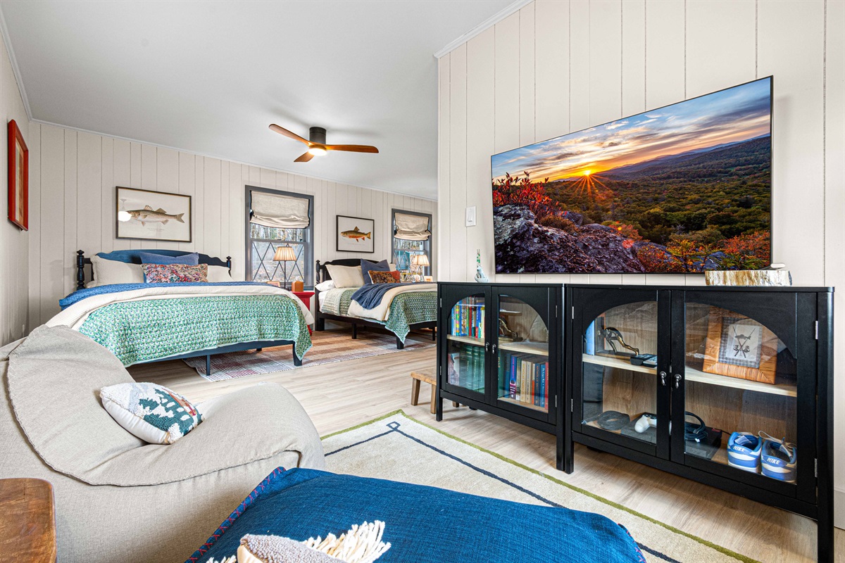 A comfortable reading and TV nook anchors the room, creating a relaxed hangout space that’s ideal for movie nights, games, or quiet downtime away from the main living areas.
