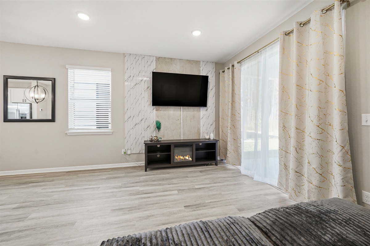 Electric fireplace sits under the huge living room TV