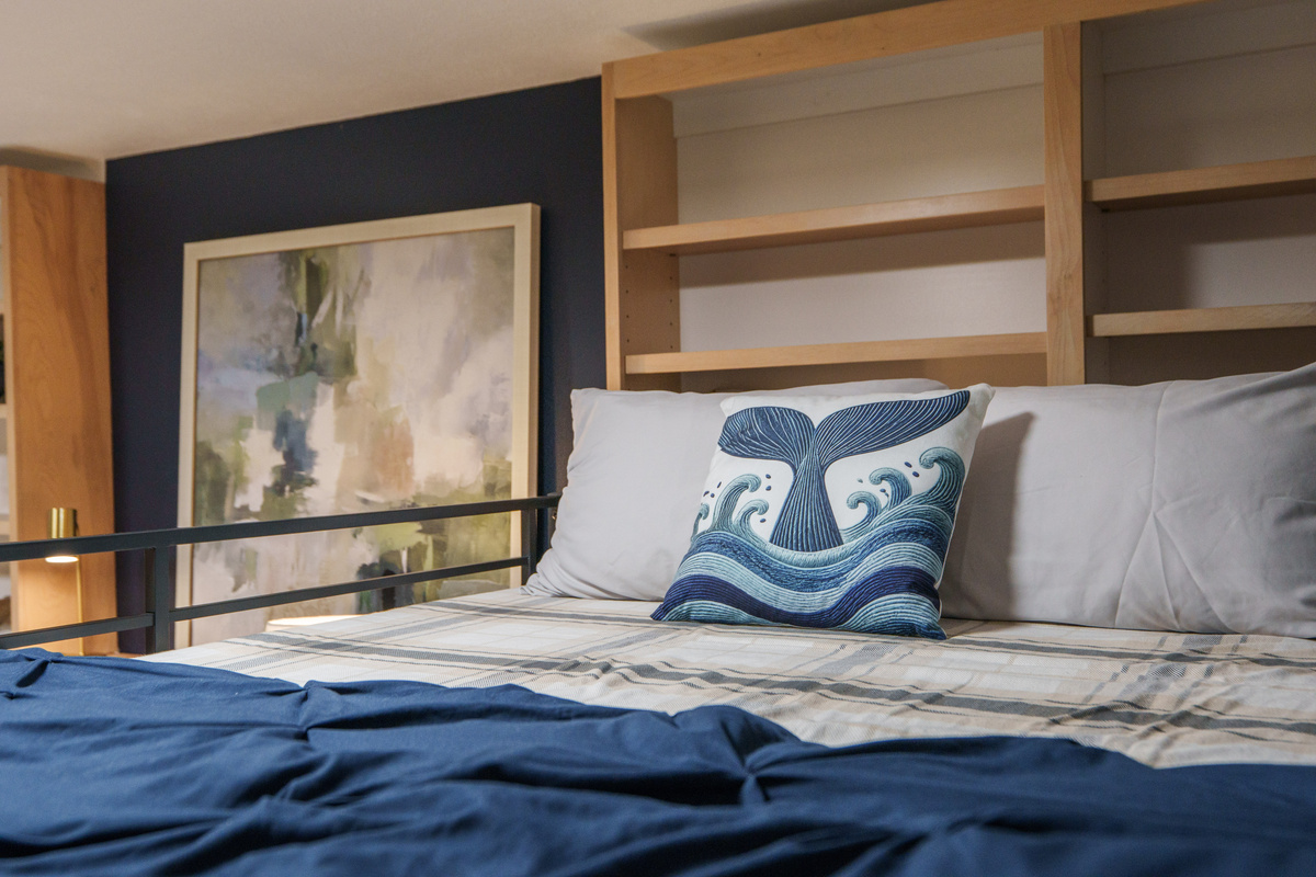 Bedroom 2 is thoughtfully designed for families and groups, featuring a queen bed, a queen-over-queen bunk bed, a dedicated remote-work desk, and a private ensuite bathroom (Bathroom 2)