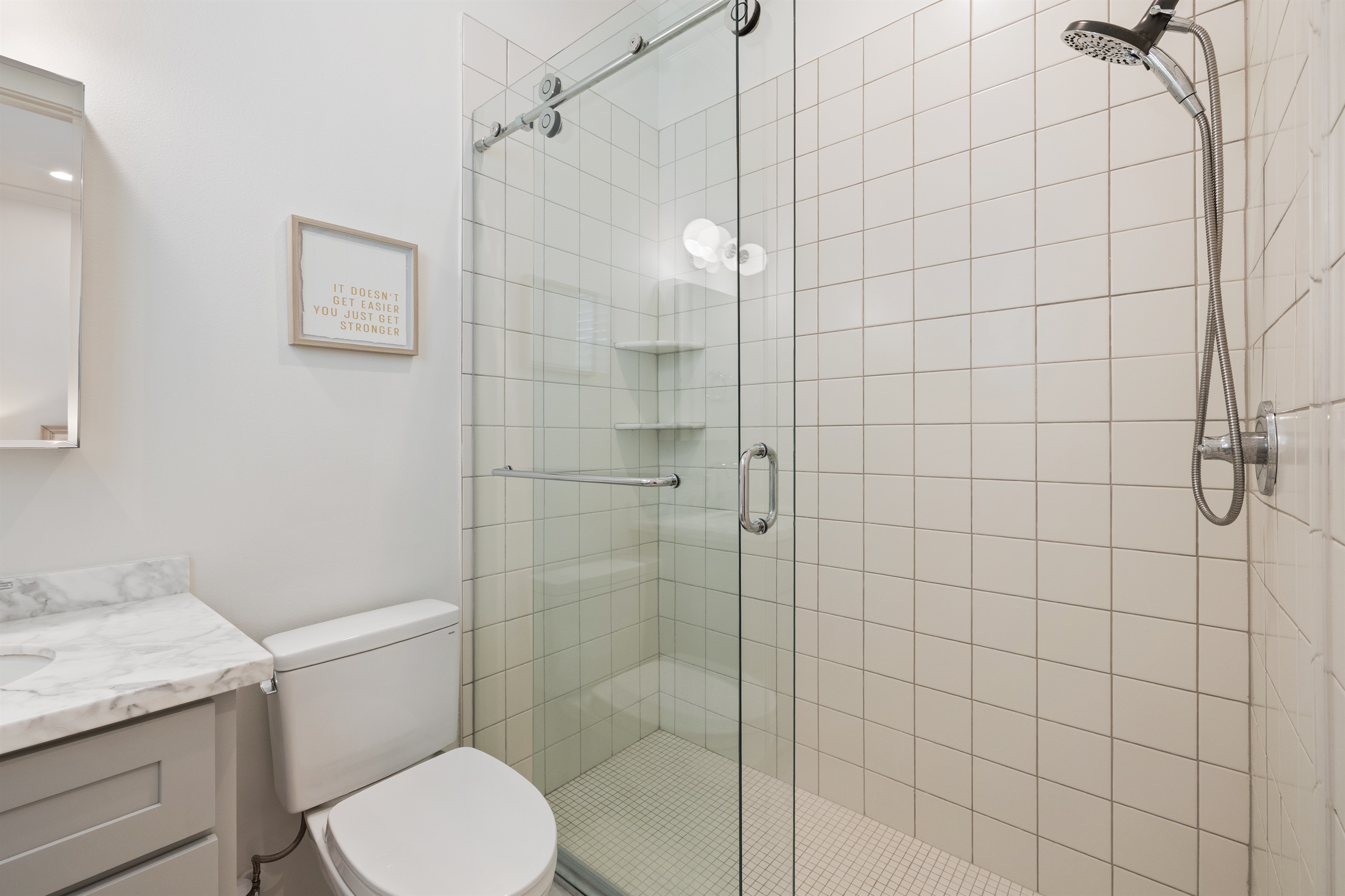 Primary bathroom includes a roomy walk-in shower and single vanity — simple, bright, and perfect for unwinding after the beach.