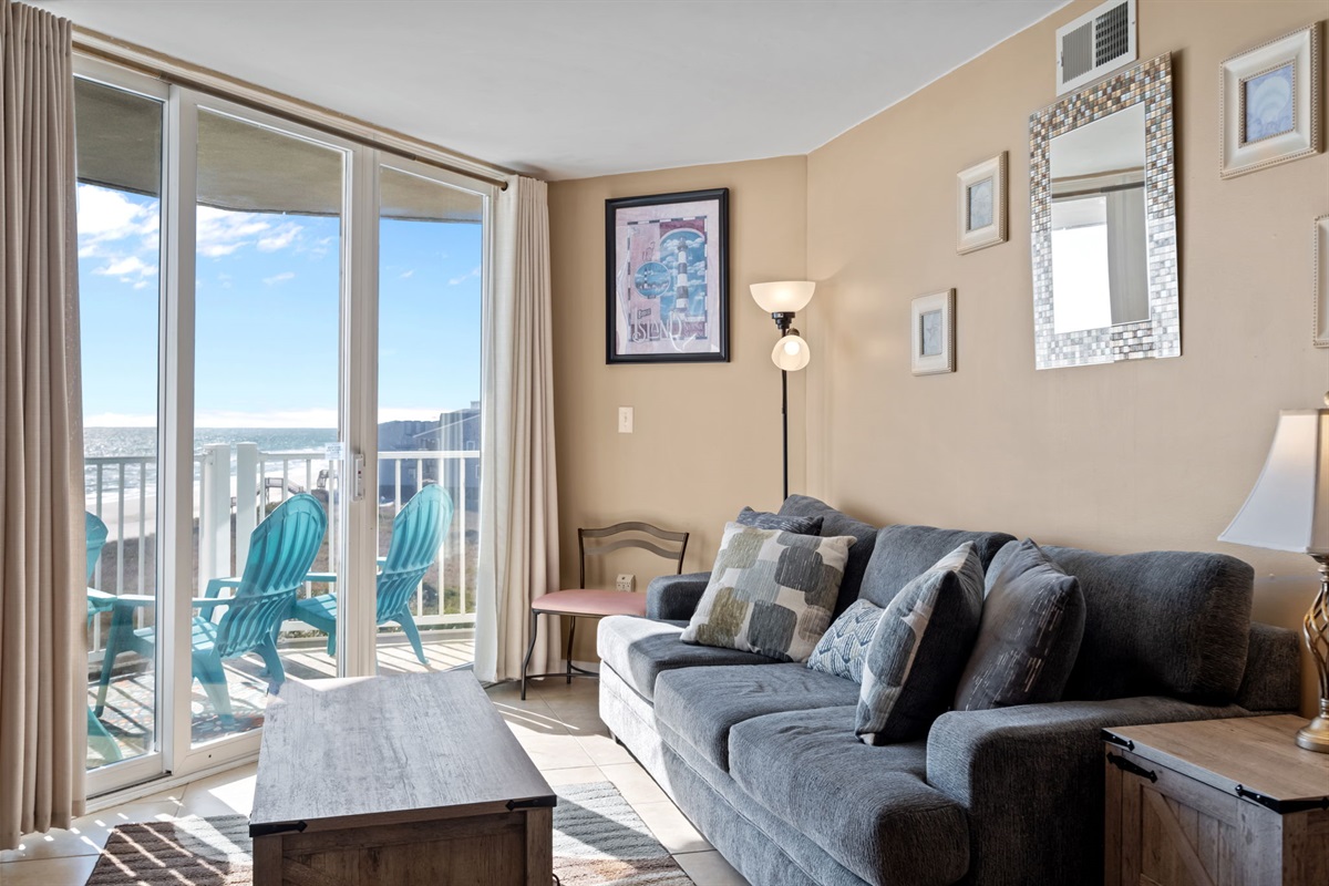 Comfortable sofa seating with direct access to the balcony, perfect for enjoying ocean views and natural light