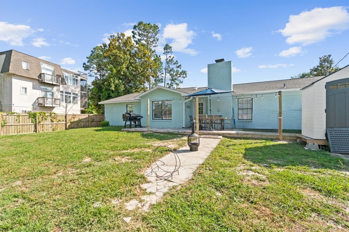 Fenced in backyard with grill and firepit