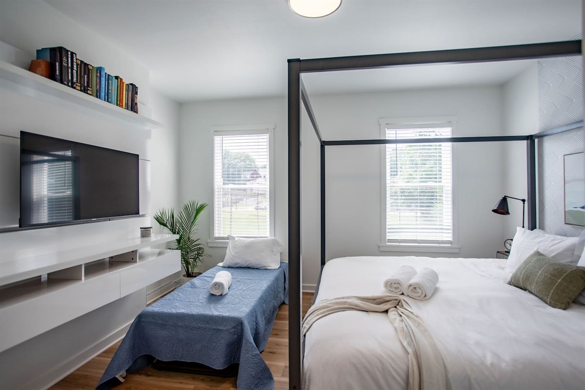 Spacious king bed complemented by an additional single bed, offering flexible sleeping arrangements for couples, families, or extra guests.
