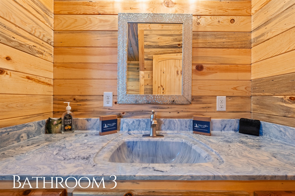 Finished with rustic cabin details, this bathroom provides a functional and comfortable space that fits naturally with the rest of the home.