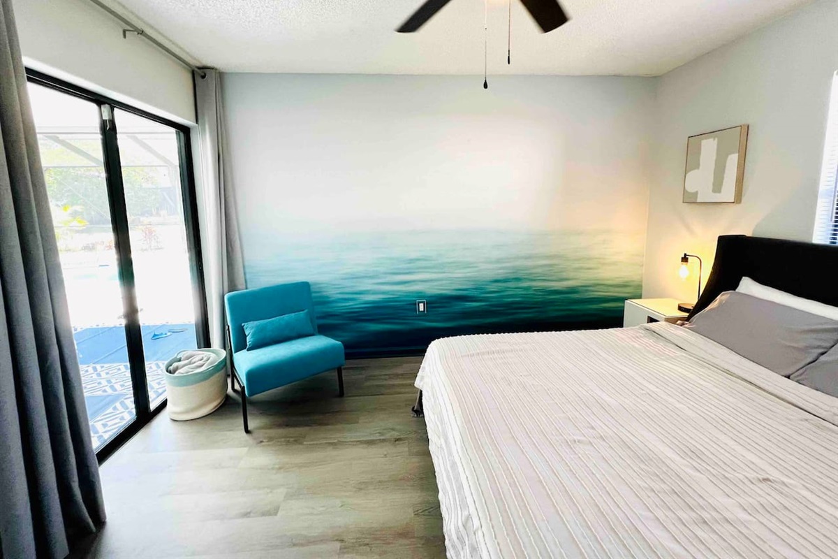 2nd bedroom with queen size bed and glass sliding door overlooking the pool area. #instagramWorthy  #uniquestay #springhillairbnb #stylishstay