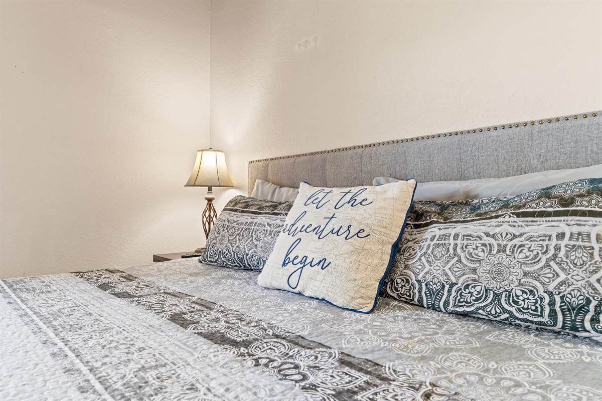 Soft bedding and calming tones help the main-level king bedroom feel restful.