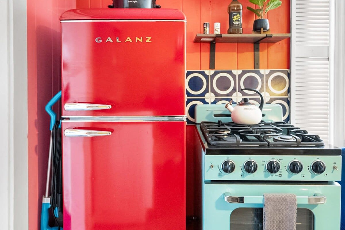 That gorgeous seafoam range up close, with the red fridge beside it and the mini-split keeping the whole room comfortable. Cook the catch, pour a glass of something, and let the evening take care of itself.