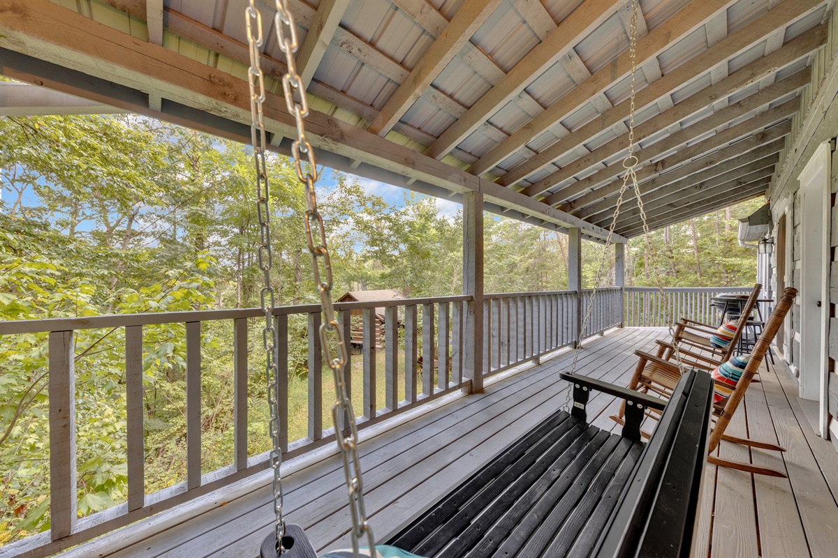 Enjoy peaceful wooded views from the comfort of the porch swing or while sipping coffee in a rocker