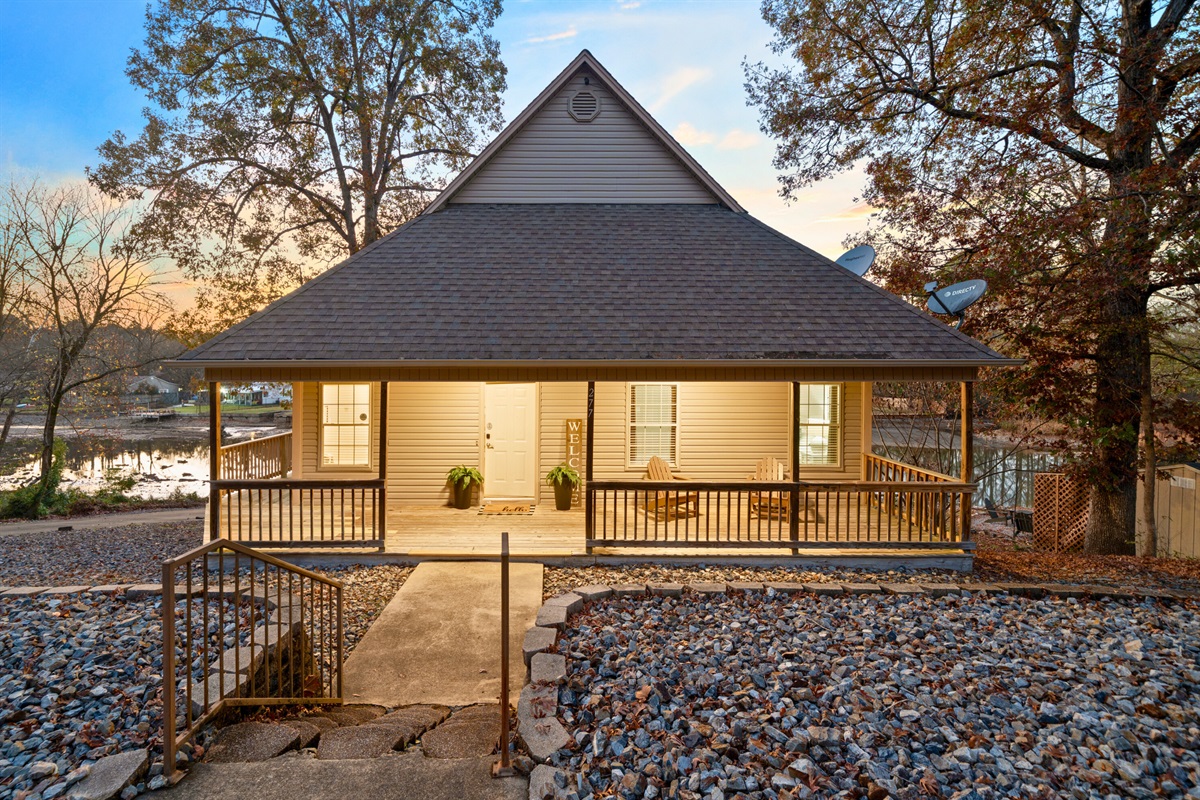 This charming view of the entryway highlights the peaceful surroundings and the inviting feel of the home&rsquo;s exterior.
