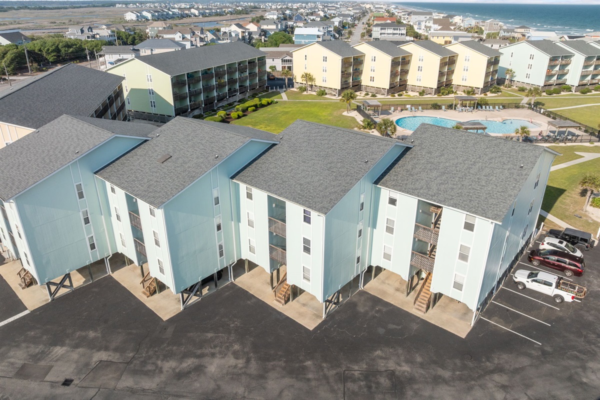 Aerial view showcasing the community, pool, and proximity to the beach