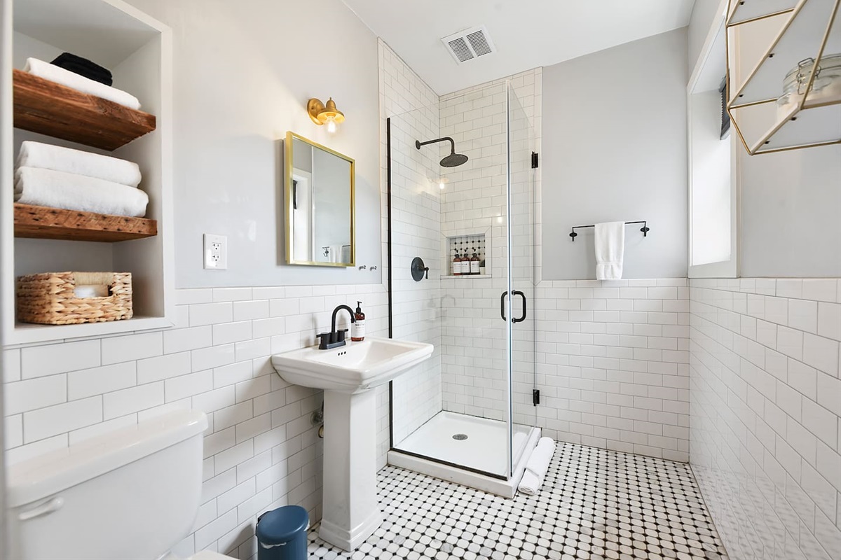 Sparkling all-white full bathroom featuring a sleek walk-in shower for a fresh, modern touch.