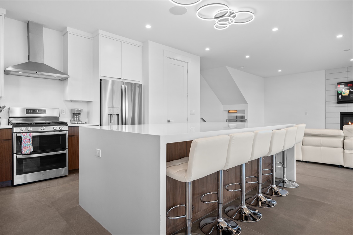 Modern chef’s kitchen with high-end appliances, quartz island, and seating for six.