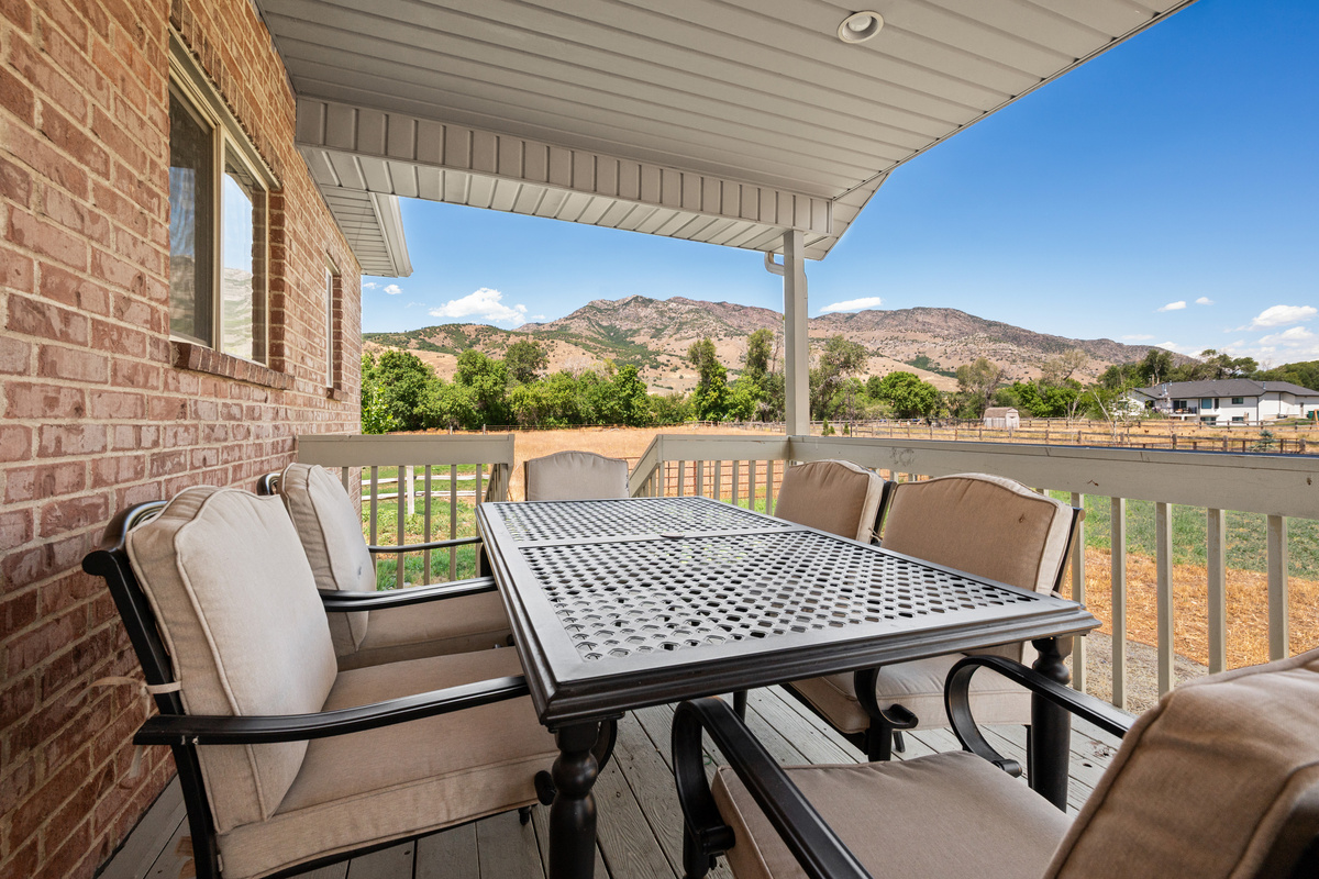 Dine outdoors beneath the covered patio while taking in expansive views of the surrounding mountains and peaceful countryside.