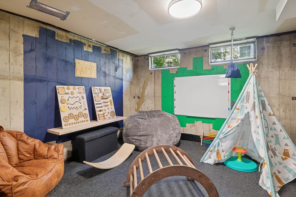 Teepee, climbers, sensory boards, and creative tools fill this industrial-chic play zone. With rotating toys and a ceiling-mounted swing, it’s built for family fun and imagination.