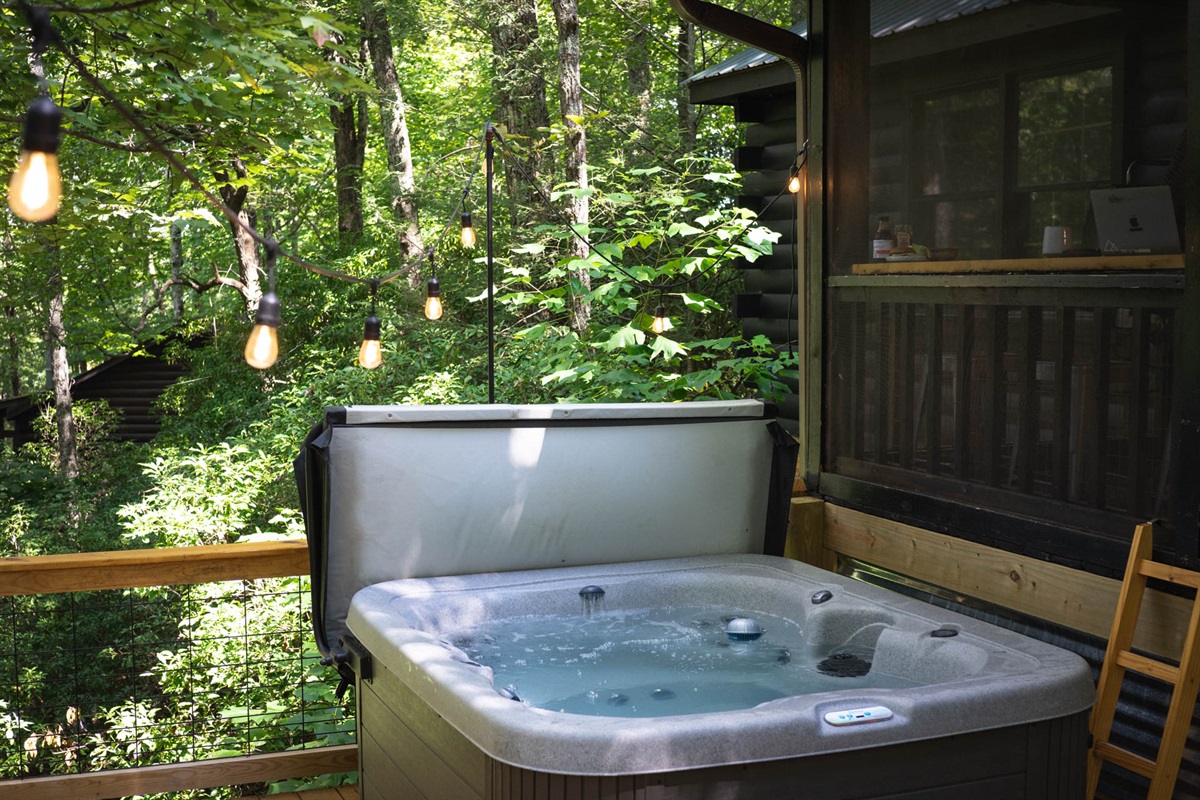 Soak in the 4-person hot tub under the trees, equipped with jets and lights