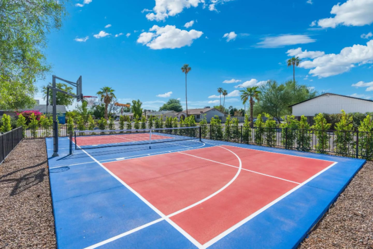 Community sports court with basketball and tennis facilities overlooking manicured grounds.