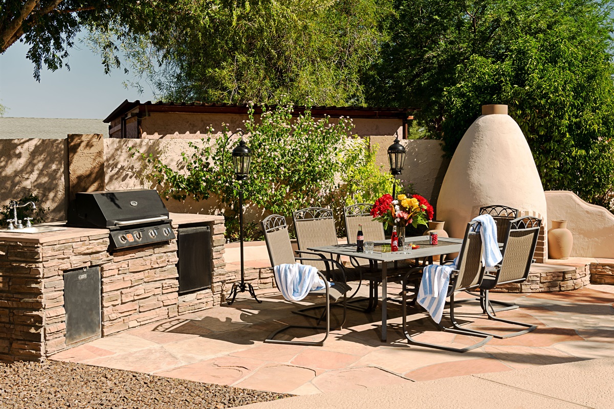 Host unforgettable outdoor meals in this sun-kissed patio space, complete with a built-in grill, elegant dining area, and charming adobe fireplace.