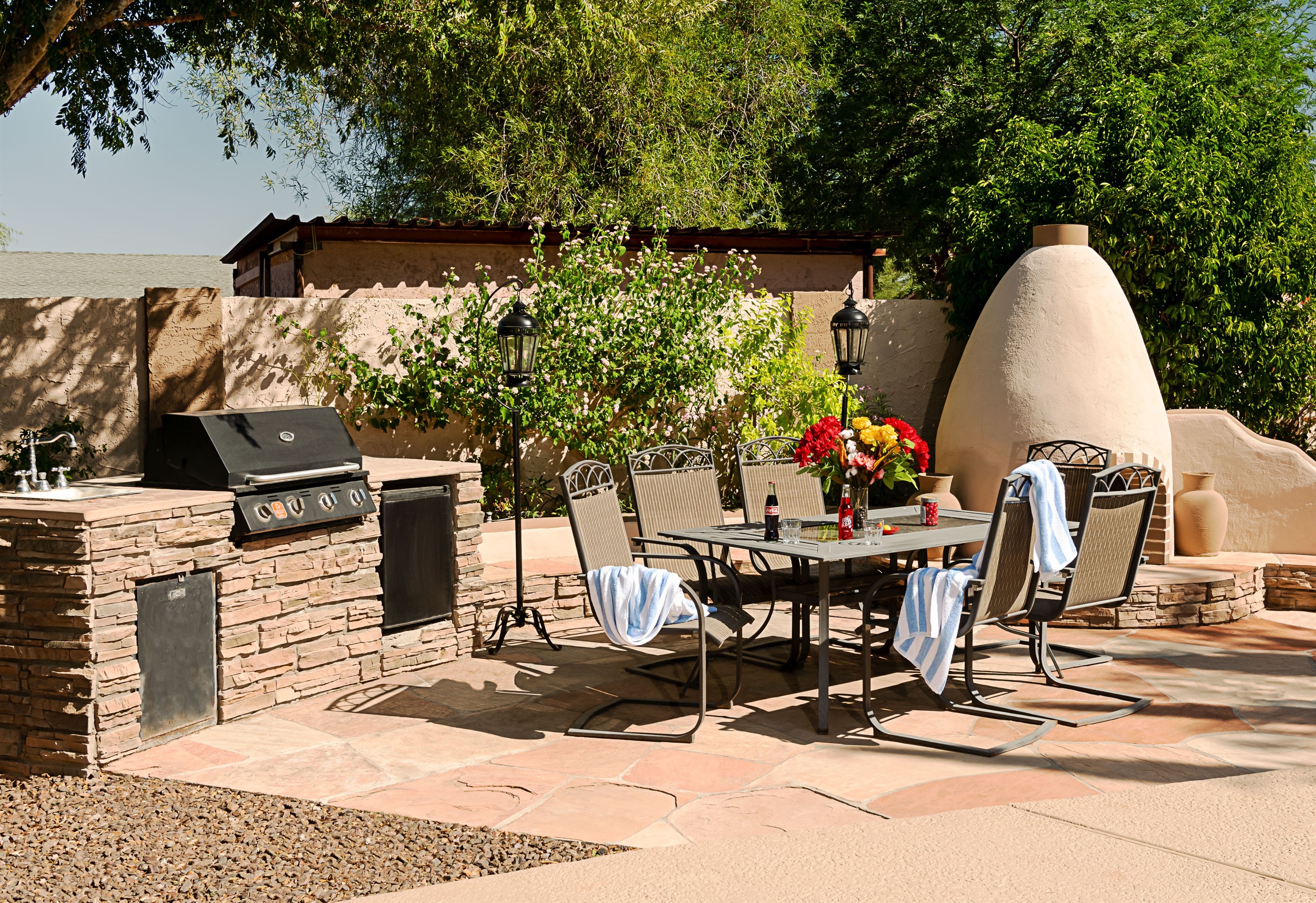 Host unforgettable outdoor meals in this sun-kissed patio space, complete with a built-in grill, elegant dining area, and charming adobe fireplace.