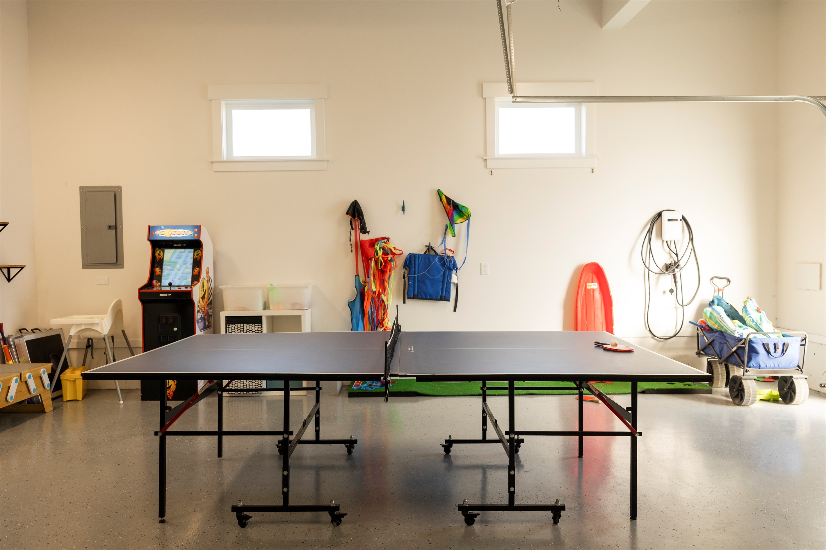 {Garage} A fun-filled game room for all ages — ping pong, mini golf, kids’ play area, and beach gear, plus a free EV charger for easy travel.