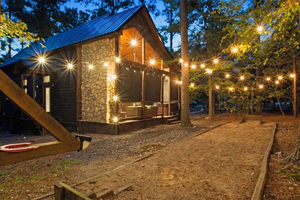 Relax under the glow of string lights surrounded by towering pines—the perfect setting for magical nights outdoors.