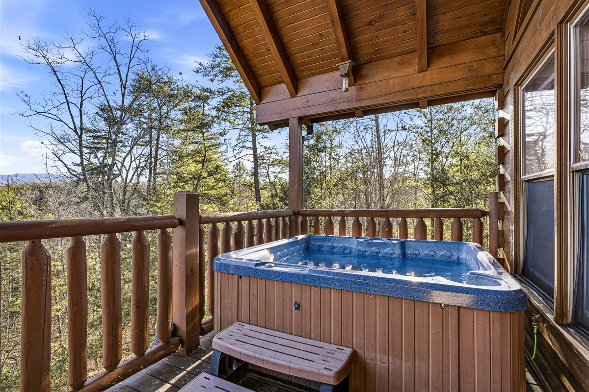 Private outdoor hot tub with Smoky Mountains forest views on the covered deck of this Gatlinburg TN cabin rental | Soak under the stars at this Great Smoky Mountains vacation cabin near Pigeon Forge & Sevierville | Hot tub cabin rentals Tennessee