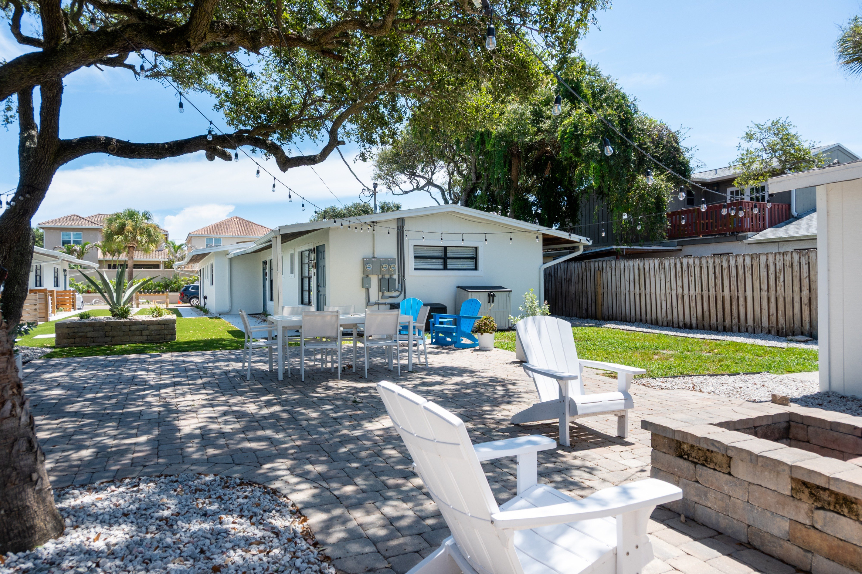 Shared outdoor area with fire pit, dining table and seating