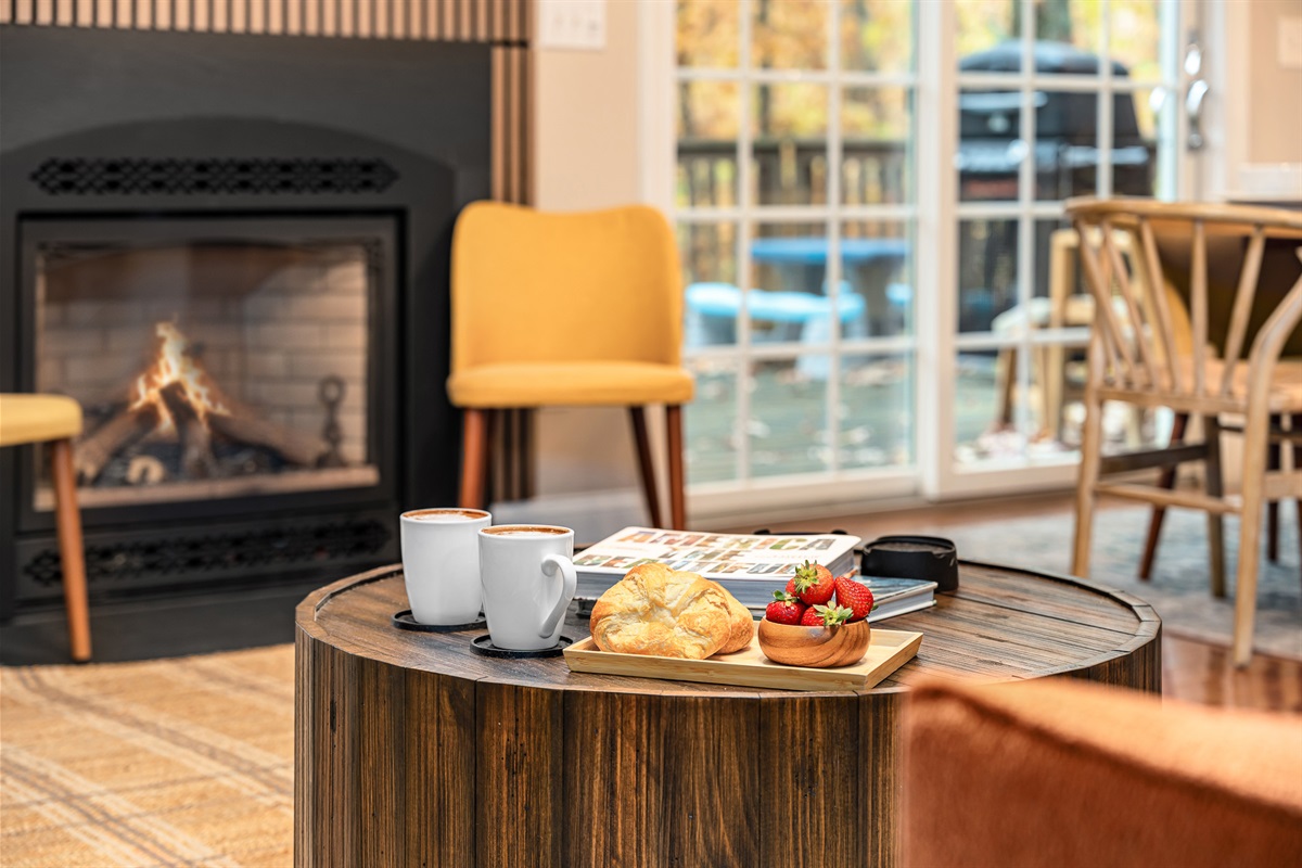 Slow mornings start here — hot coffee, warm fire, and the forest right outside your window