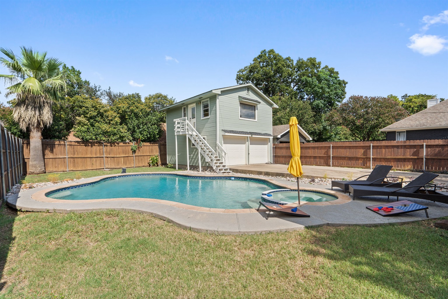 Private unheated Pool with sun loungers, patio seating, and fully fenced backyard. Outdoor furniture and umbrella included. Shared between main house and Detached Studio guests. Dallas, TX.