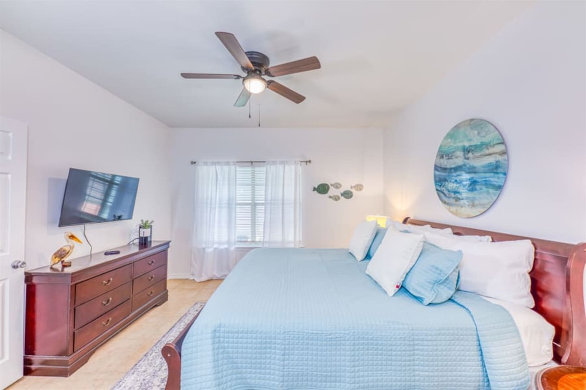 Master Bedroom: Bright aquatic vibes with a spacious bed and a refreshing view to unwind!