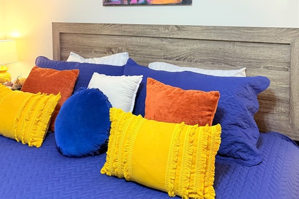 A mix of bold pillows and soft bedding makes this bedroom as fun as it is comfortable. 