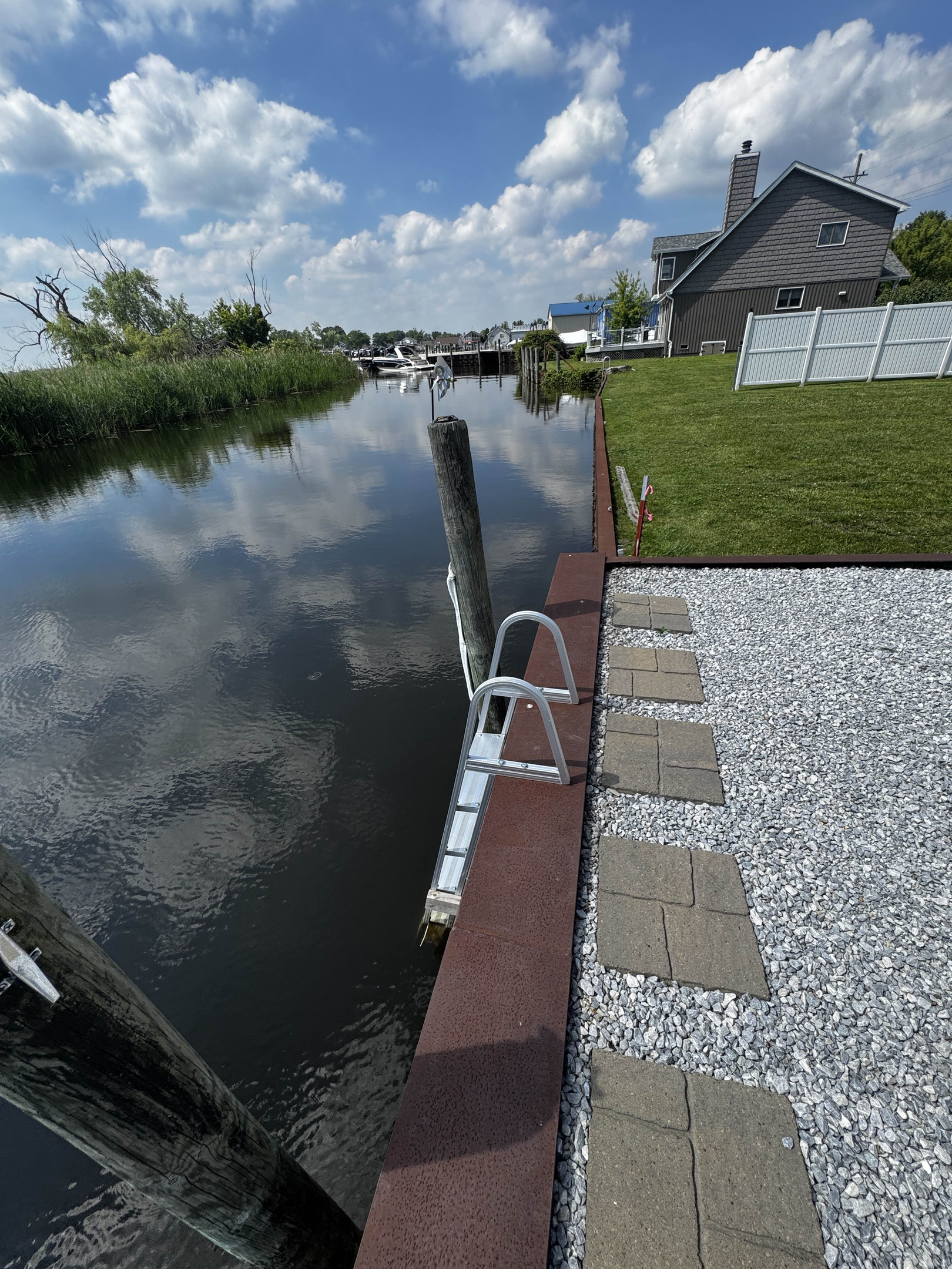 Private waterfront dock with ladder access, offering direct entry to the calm canal and peaceful water views.