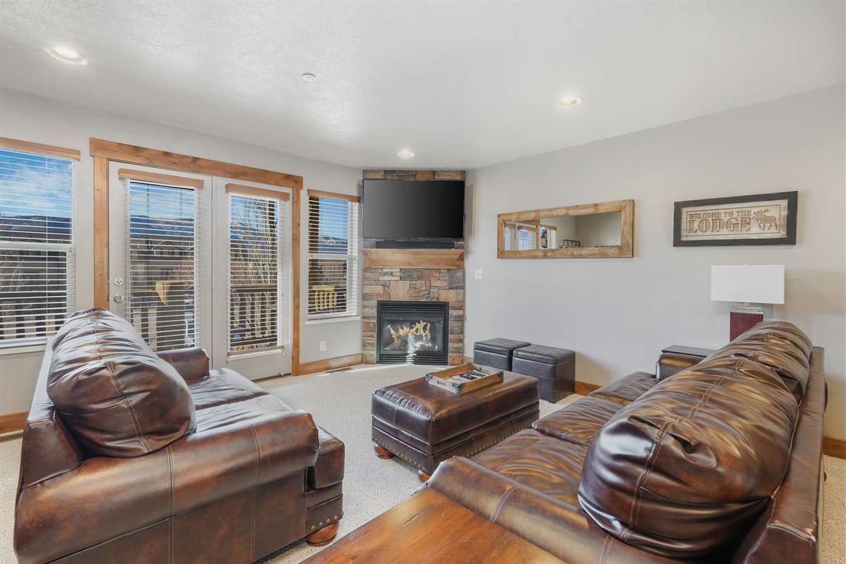 Cozy up in the inviting living room with plush seating and mountain views—perfect for relaxing after a day of adventure.