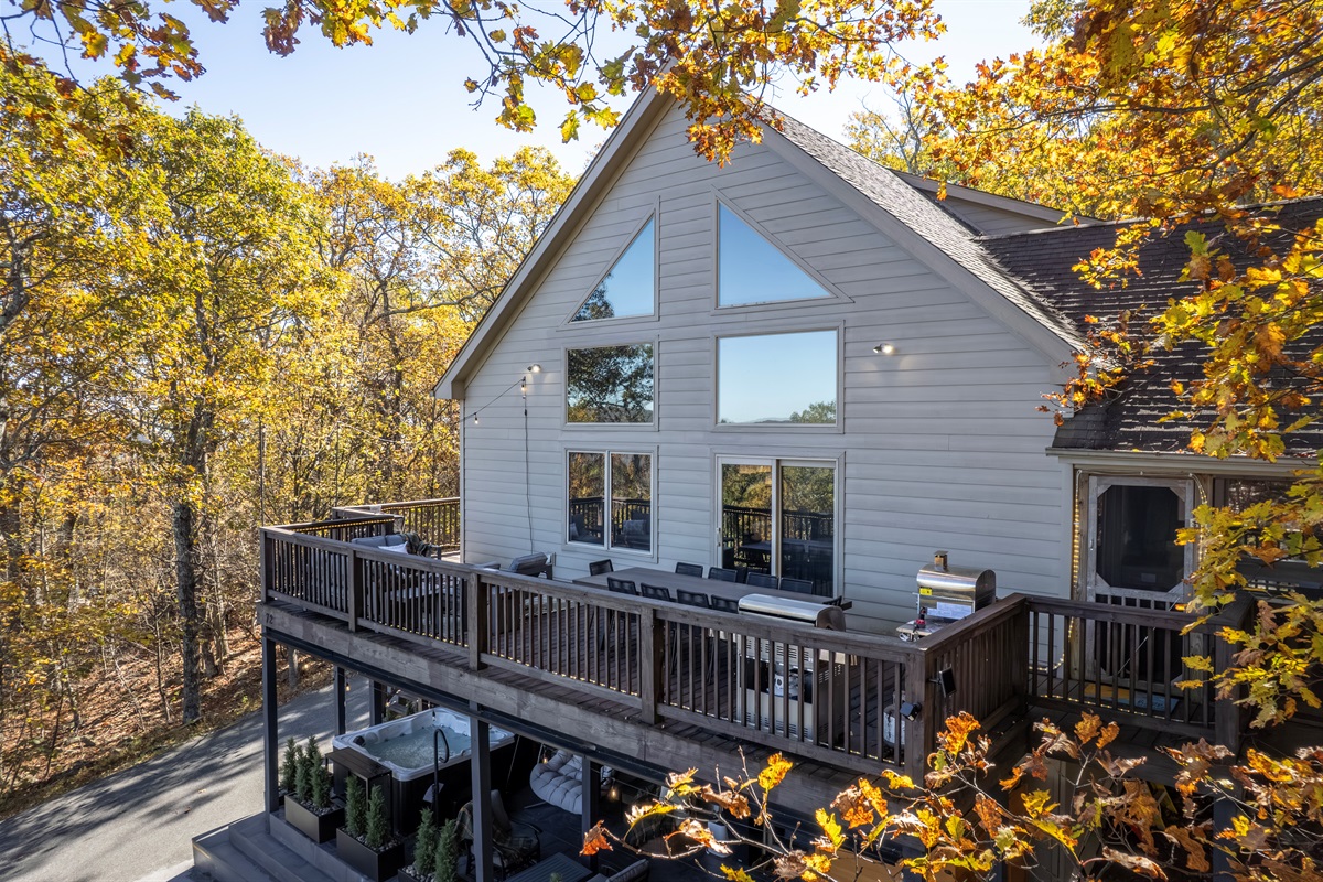 Framed by autumn leaves, the chalet’s soaring windows and wraparound deck invite gatherings in fresh mountain air and glowing seasonal light.