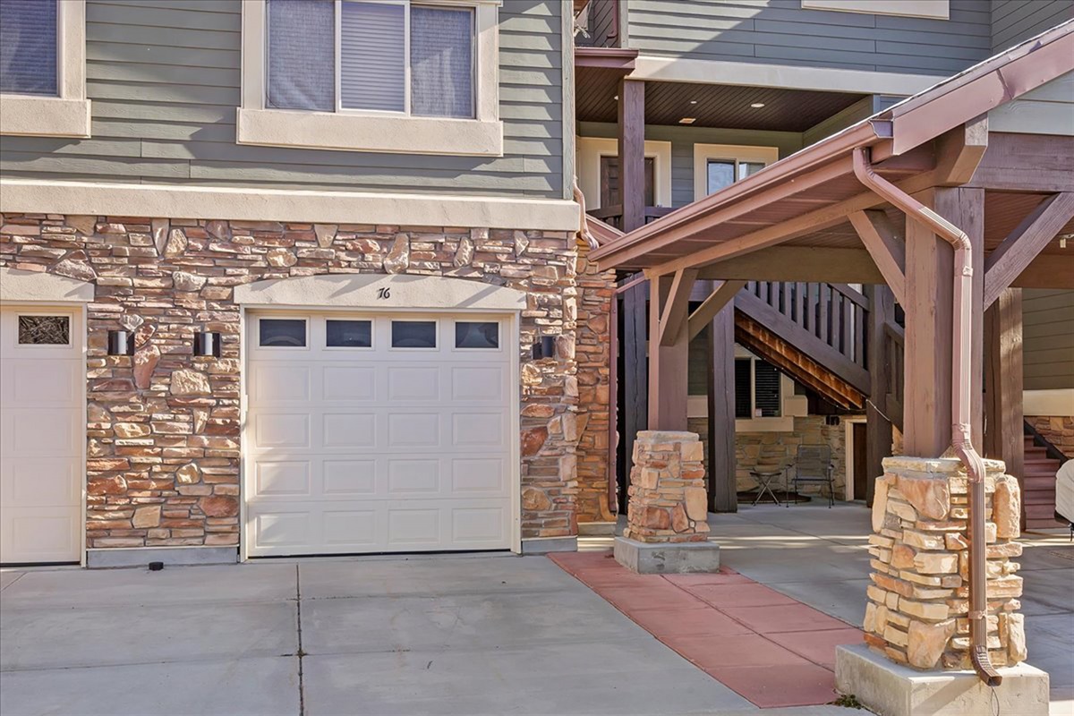 A welcoming exterior entry framed by rich stonework and timber accents, showcasing timeless alpine architecture and curb appeal.