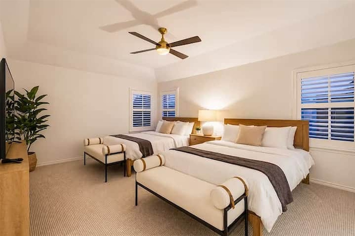 Spacious bedroom with plush bedding and natural light