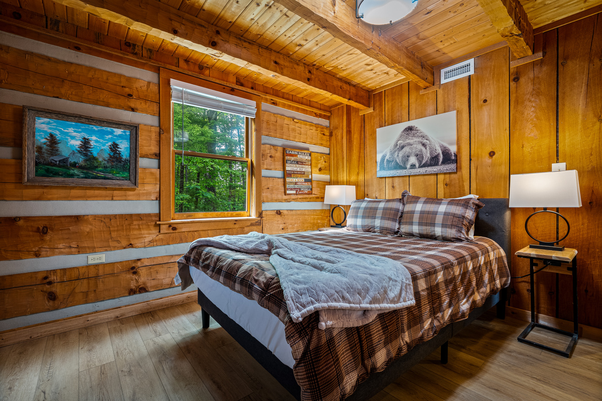 Main level bedroom, with a queen bed, quilt and bedside lamps
