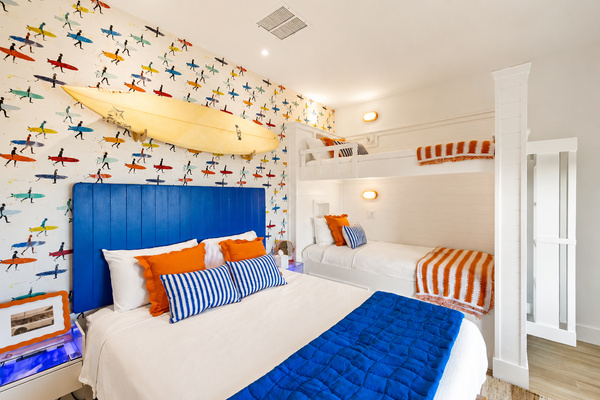 The Sunrise Surf Shop themed Bedroom includes spacious bunk beds, a comfortable queen bed, beautiful views and nearby access to the second floor balcony. Guests will utilize the half bath on the main floor and shower in another guest suite.