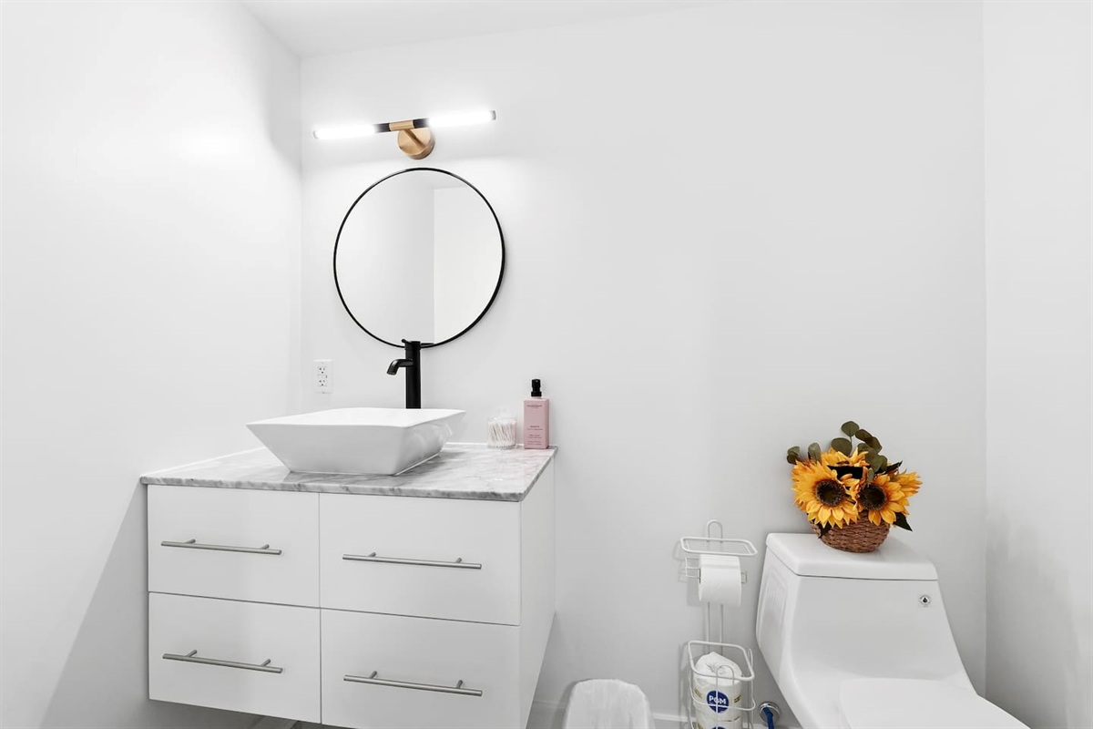 Sweet modern half bathroom located in the basement by the entertainment area. 