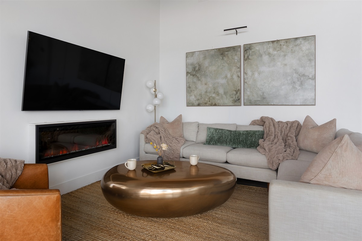 {Living Room} A soft, neutral lounge space anchored by a warm fireplace—designed for slow mornings and late-night conversations.