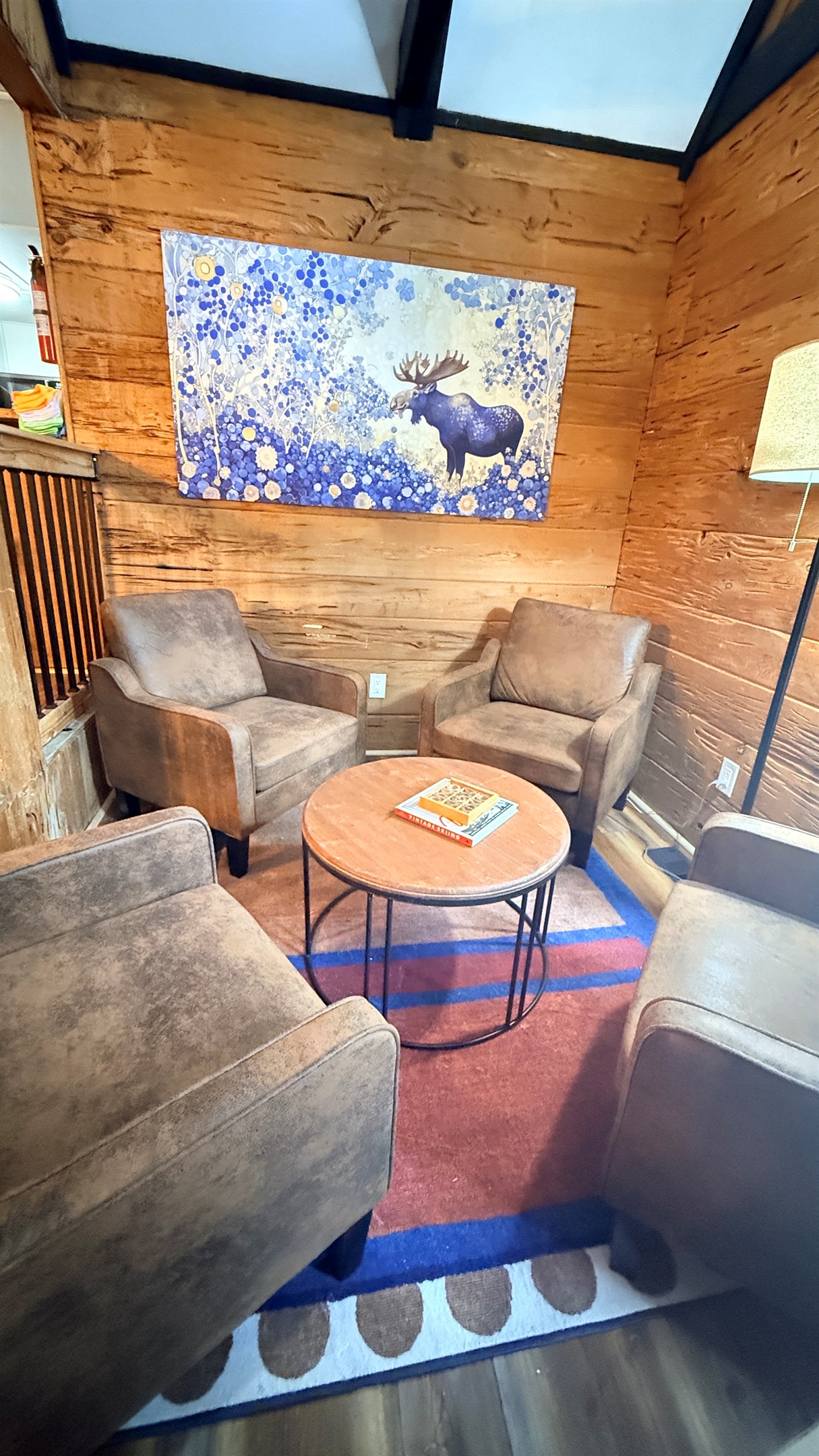 Kick back in your cozy lounge nook—perfect for morning coffee, late-night chats, or diving into a good book beneath the warm glow of the lamp and rustic charm all around.