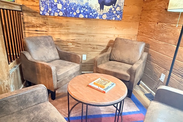 Kick back in your cozy lounge nook—perfect for morning coffee, late-night chats, or diving into a good book beneath the warm glow of the lamp and rustic charm all around.