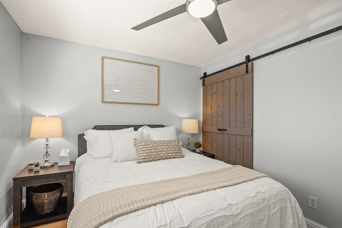 Bright upstairs bedroom featuring a queen bed and comfortable accommodations for guests.