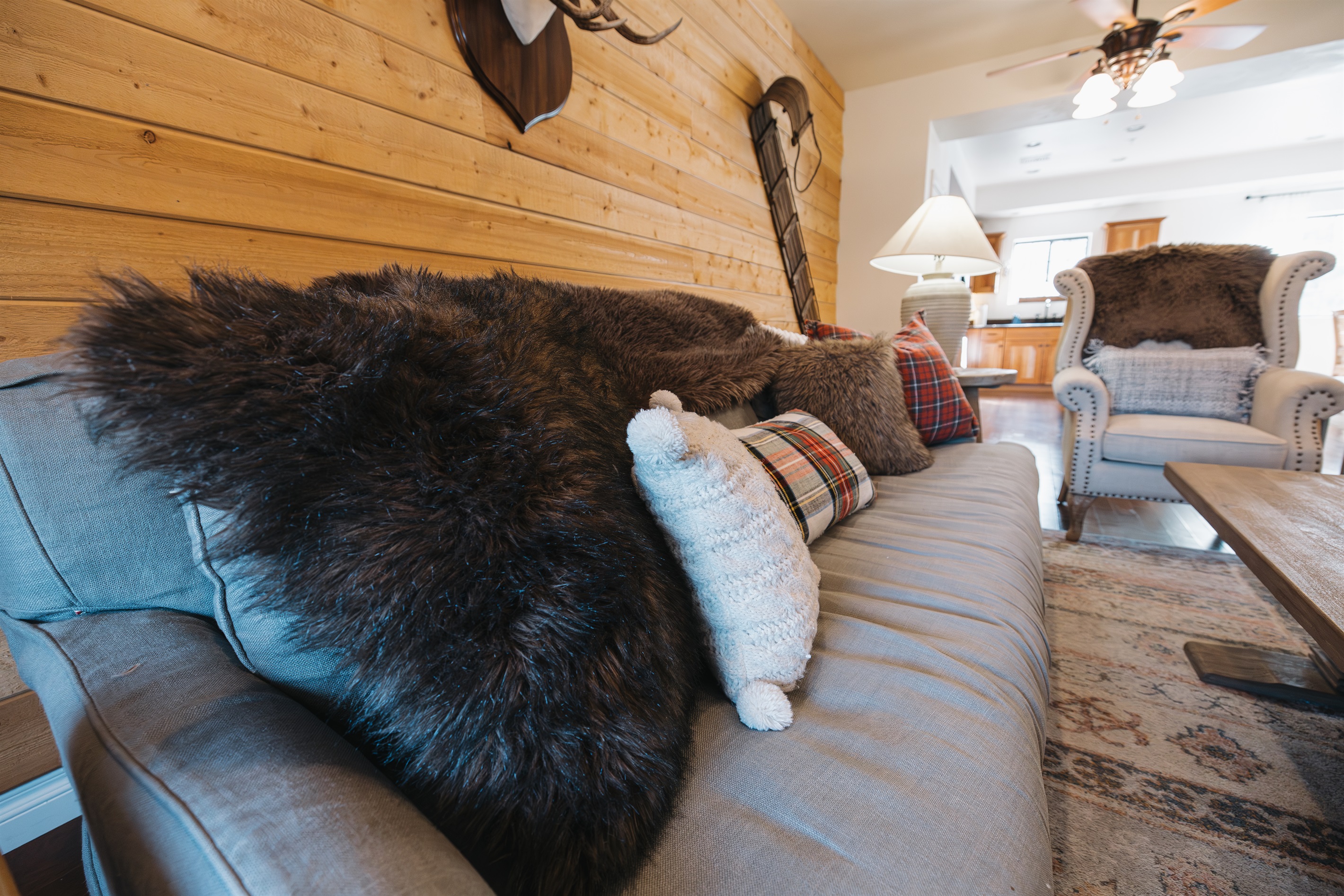 Sink into plush seating layered with cozy throws and cabin-inspired textures. This inviting living space is perfect for movie nights, relaxing after mountain adventures, or slow mornings with coffee.”