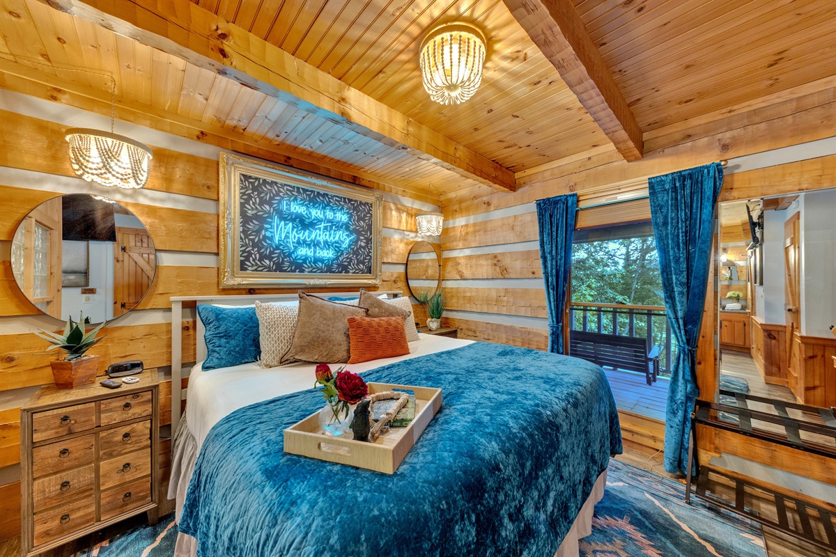 King bedroom with a large picture window and warm cabin charm