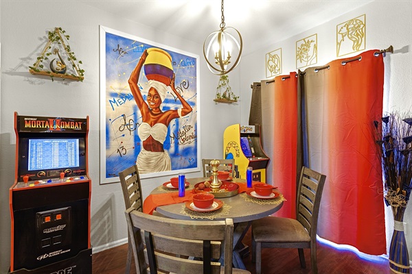 Fun and vibrant dining area with a retro arcade game and colorful decor. Perfect for family meals and game nights.