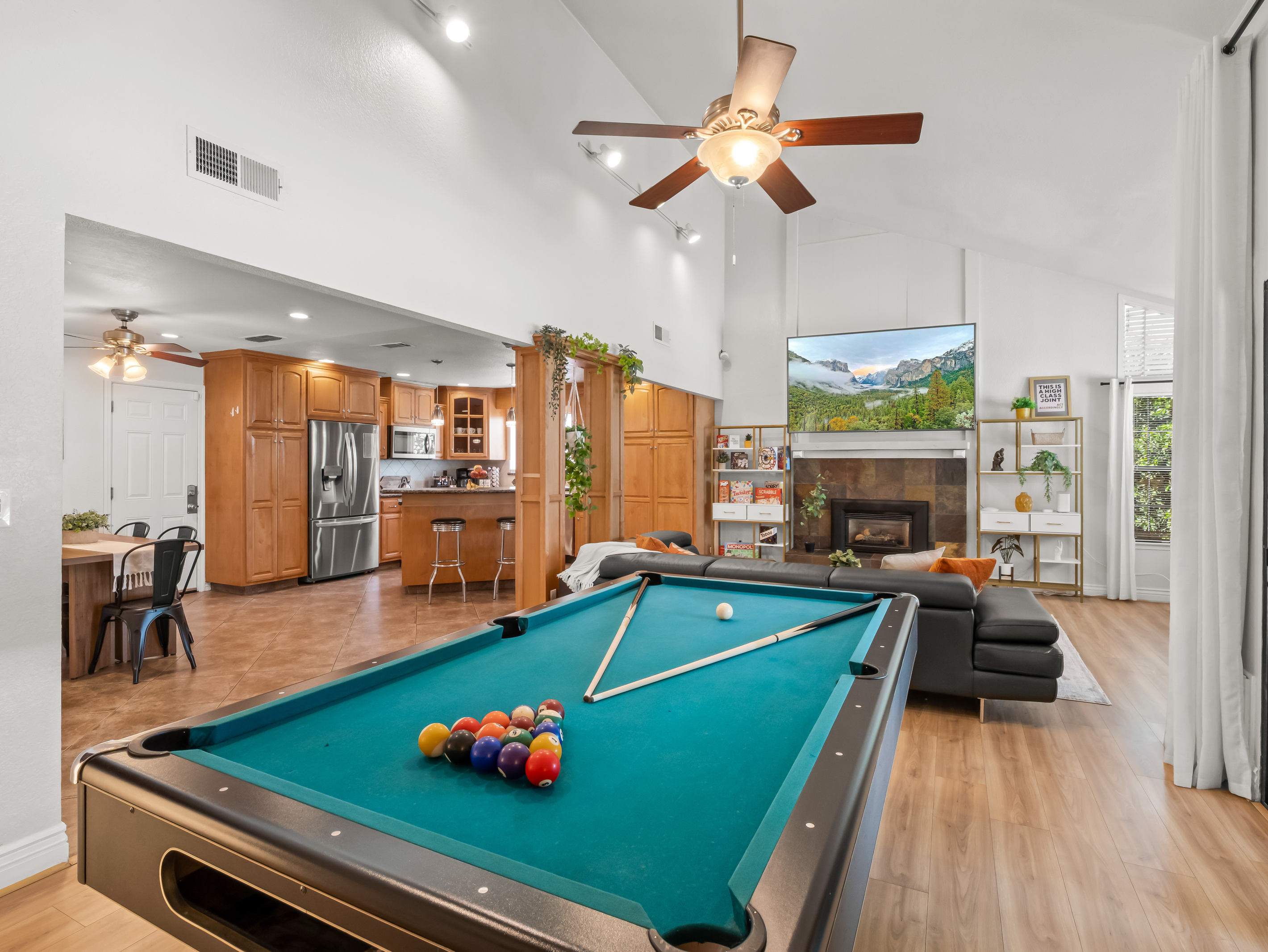 Perfect for families and groups, the open-concept main living area combines a full-size pool table, spacious lounge, fireplace, large TV, kitchen, and dining space for easy group entertainment.