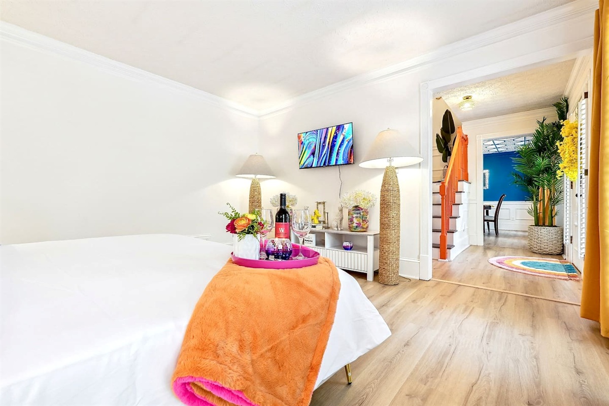 Bedroom 1 is located on the main level and features a king-size bed, TV, and a no ensuite bathroom. A nearby half bathroom is available for guest use.