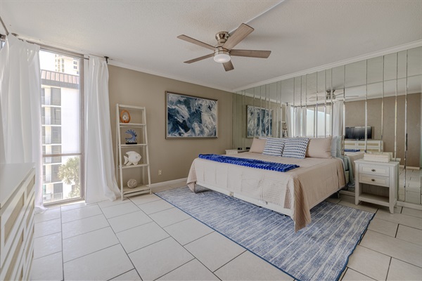 Master bedroom #1 with ensuite bath, ceiling fan, smart TV, and balcony access