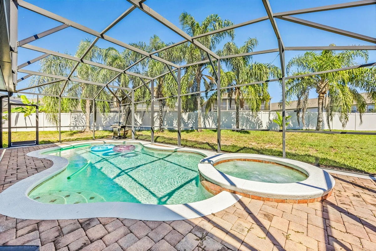Dive into vacation mode! Enjoy your private screened-in pool and bubbling spa surrounded by Florida sunshine and palm trees.